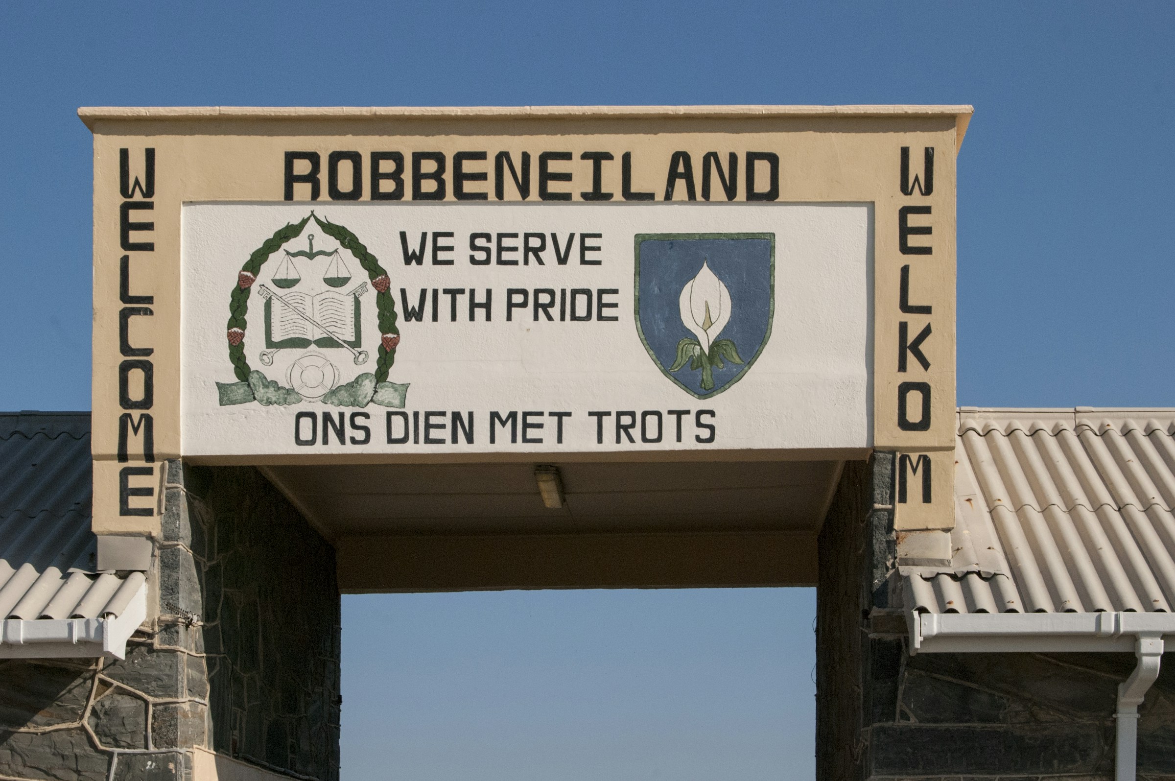 The entrance sign at Robben Island: 'We serve with pride'